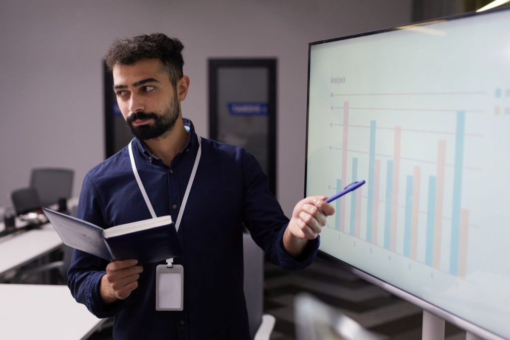 business meeting pointing to an interactive smart whiteboard screen